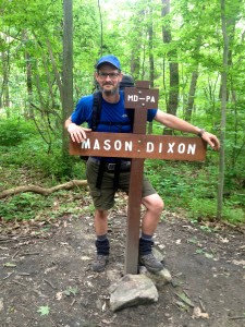 Appalachian trail thru hiker Slim Jim aka Chris Spencer crosses the Mason Dixon line