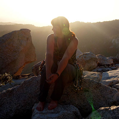 Christina Armbruster sitting on rock at sunset