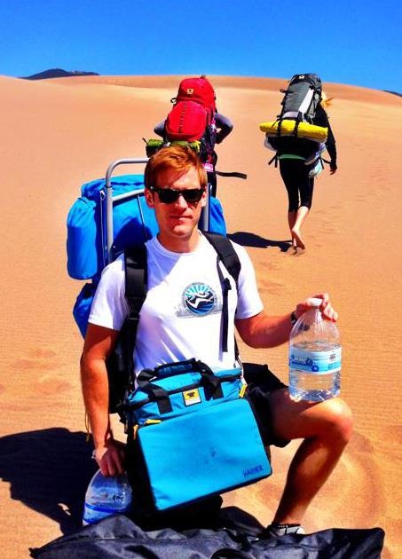 hiker carries the Mountainsmith deluxe cooler cube in Colorado's Sand Dunes