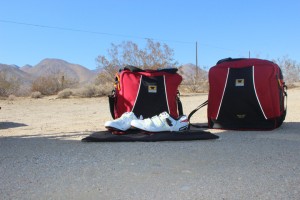 The Mountainsmith Bike Cube Deluxe with shoes in front of it on the changing pad