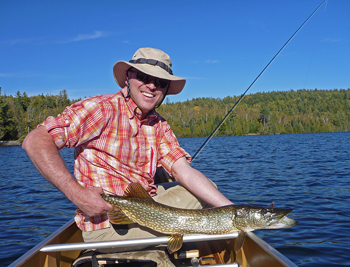 Jon Hill holding a fish in the Boundary Waters Canoe Area