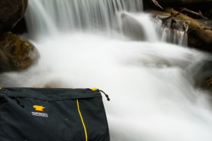Mountainsmith Tour FX camera lumbar pack in front of a waterfall
