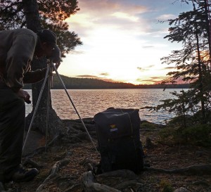 Randy Wilson taking a photo of the sunset with his Mountainsmith Spectrum camera backpack