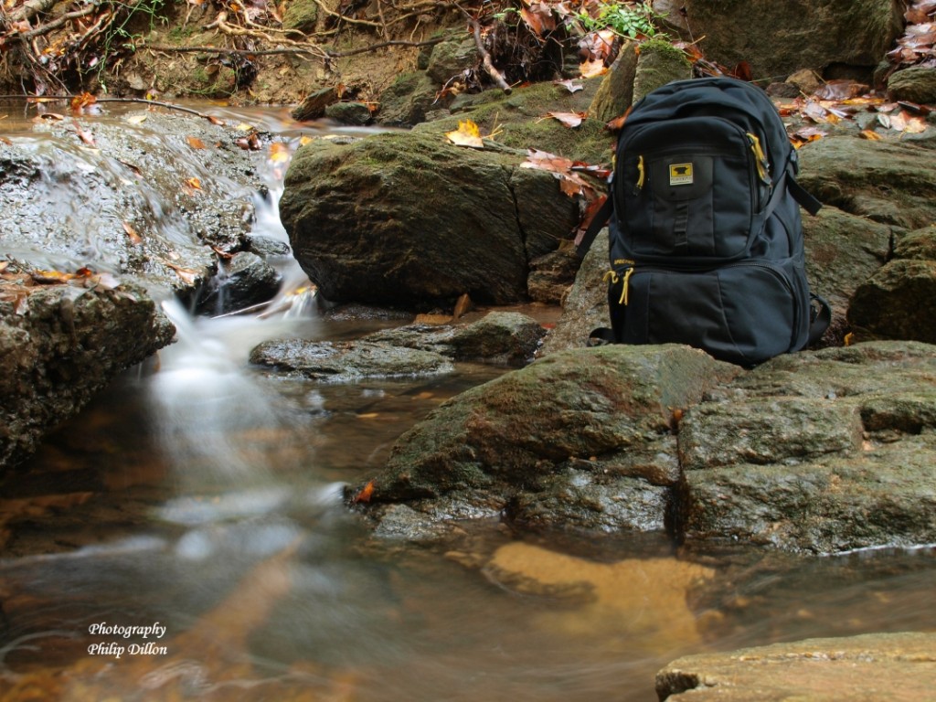 The Mountainsmith Spectrum Photography backpack next to a waterfall shot by Phil Dillon with a long exposure