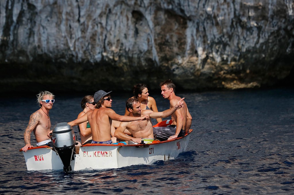 climbers wait their turn in a boat for a chance to deep water solo climb near olympos turkey