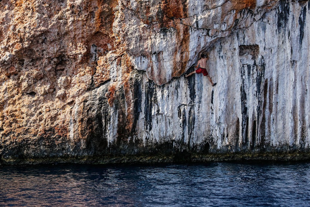 A climber is spread eagle while deepwater solo cimbing near olympos turkey