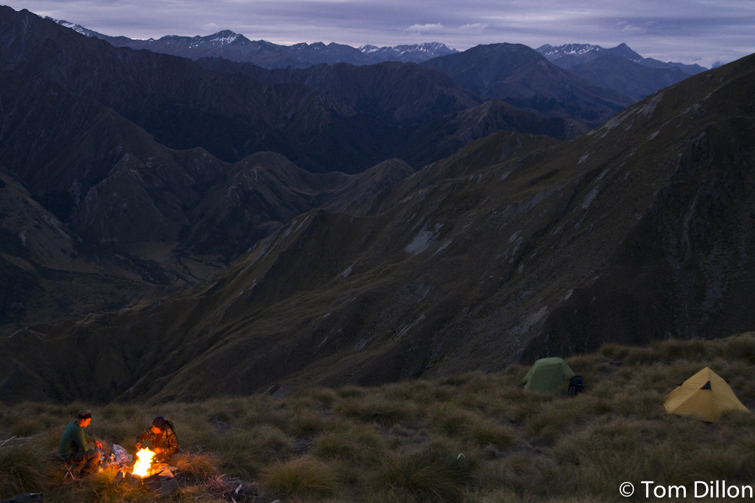 campfire and two tents in the mountains in new zealand