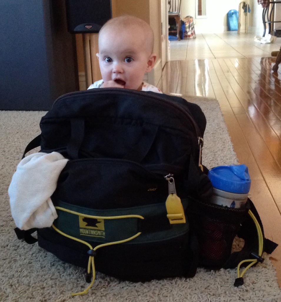 a baby sits behind a Mountainsmith Day pack being used for a diaper bag