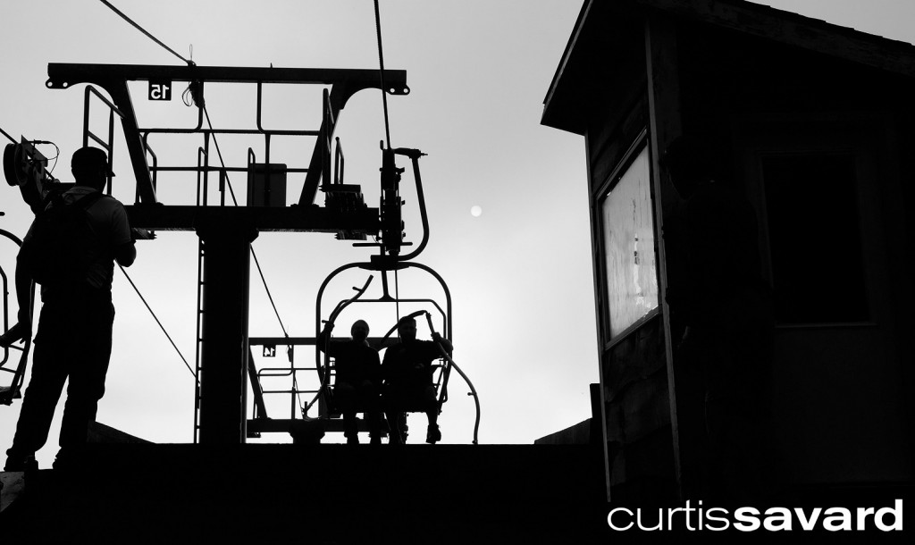 silhouette of two mow crew workers riding the mad river glen double chair