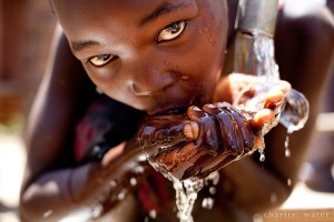 Ugandan Child drinking from a charity: water well